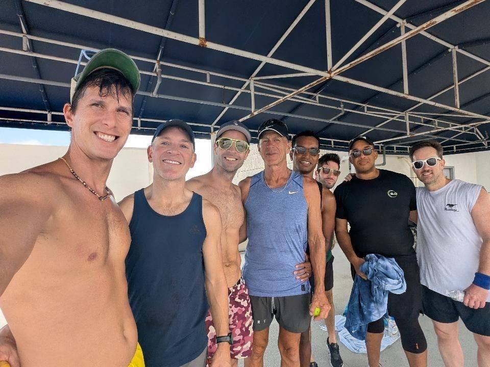 A group of queer pickleball players smiling together for a selfie after playing