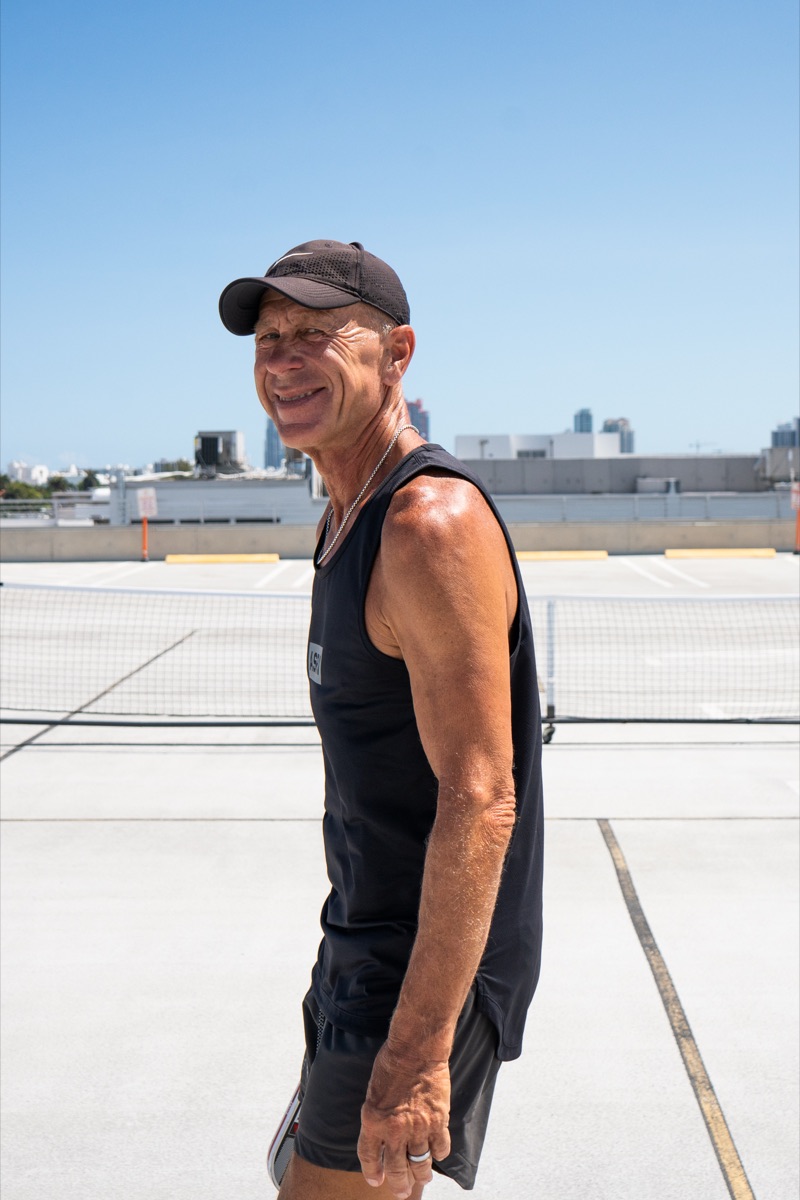 A smiling pickleball player in the Miami sun with the skyline behind him